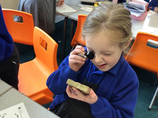 A pupil takes a closer look at one of the rocks