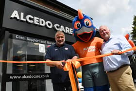 Wigan rugby legend Shaun Wane, left, officially opens the new offices for Alcedo Care, in a former bank on Ormskirk Road, Pemberton, pictured with Alcedo Care's managing director Andy Boardman, right,  and the company mascot Al