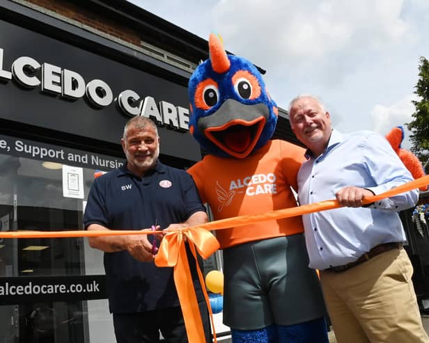 Wigan rugby legend Shaun Wane, left, officially opens the new offices for Alcedo Care, in a former bank on Ormskirk Road, Pemberton, pictured with Alcedo Care's managing director Andy Boardman, right,  and the company mascot Al