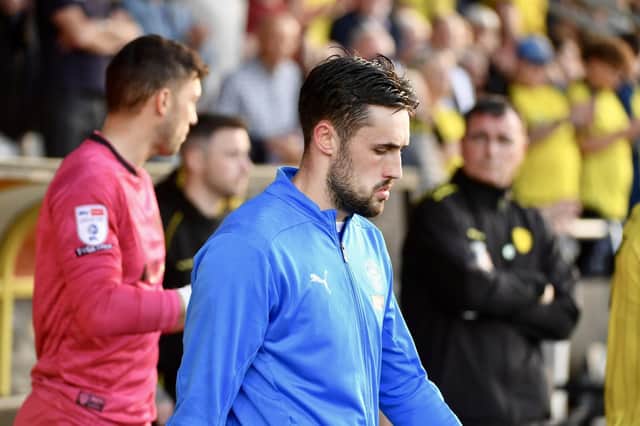 James Carragher leads Latics out at Burton