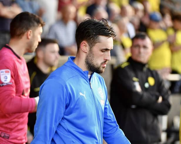James Carragher leads Latics out at Burton