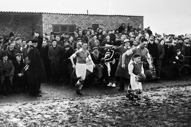 Wigan Athletic captain Dave Mycock leads the team out at Springfield Park for the FA Cup 3rd round replay against Newcastle United on Wednesday 13th of January 1954.
Lancashire Combination side Latics had drawn the first match 2-2 at St. James Park on the previous Saturday against the "Magpies" who were at the height of their glory years with a team that included legends such as Jackie Milburn, Jimmy Scoular and Ivor Broadis.
Despite two goals from centre forward Billy Lomax Latics lost 2-3 but not without a great fight.