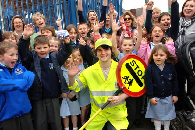 Pupils and parents give a big cheer to their new lollipop man, Neil Gorton, outside Our Lady Immaculate RC Primary School, Downall Green Road, Bryn, on Wednesday 29th of April 2009.  Neil, aged 21, from Eddleston Street, Bryn, was a young actor who worked on two top drama series, 'Unforgiven' on ITV and 'Waterloo Road' on BBC but whilst still on his agent's books but going through a quiet time took the job as lollipop man on the advice of his grandad.