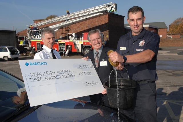 RETRO 2007 Firefighter John Houghton, who organised a charity car wash by Green Watch at Wigan Fire Station, right, and Deputy Borough Commander Paul Petrykowski, present Wigan and Leigh Hospice volunteer fundraiser Ken Rees with a cheque for £300.  Three other charities were also given a share of the £1,200 total raised.