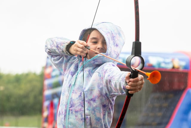 A youngster tries out archery at the Speed of Sight family fun day
