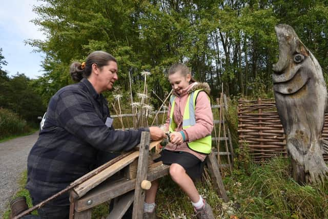 Twiggy from Greenwood Twiggs creates flowers from shaving branches with a pupil from St Peter's Hindley