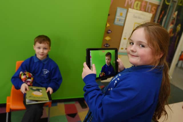 Pupils are working with green screen technology in the classroom.