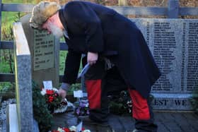 Relatives and members of the community lay wreaths at the memorial stone.