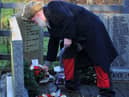 Relatives and members of the community lay wreaths at the memorial stone.