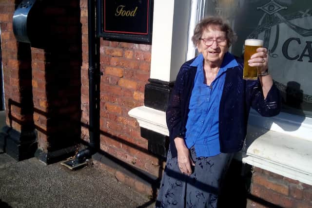 Dorothy Randles, 100, raises a pint at the pub