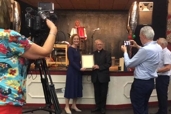 Canon Pat MacNally receives a certificate, a moment captured for Irish television