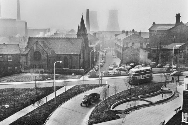 A view across the bottom end of Millgate and Rodney Street towards Chapel Lane with Trinity Methodist Church on the left and Wigan gas works and Westwood cooling towers in the background in the late 1960s.