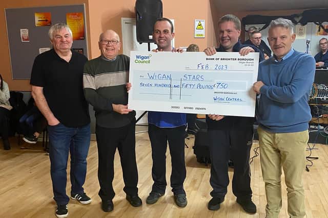 Councillors George Davies, second left, and Lawrence Hunt, right, hand the cheque to Wigan STARS volunteer Steve Ramage and members Craig Houghton and Stuart Mills