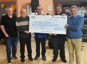 Councillors George Davies, second left, and Lawrence Hunt, right, hand the cheque to Wigan STARS volunteer Steve Ramage and members Craig Houghton and Stuart Mills