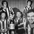 Wigan Athletic goalscoring hero Maurice Whittle holds the champagne as he celebrates with team-mates Mickey Worswick and Billy Styles, front, and John Wilkie and Kenny Morris after the match against Division 3 Sheffield Wednesday in the FA Cup 2nd round match at Springfield Park on Saturday 17th of December 1977. Latics won the game 1-0.