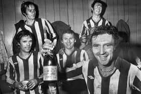 Wigan Athletic goalscoring hero Maurice Whittle holds the champagne as he celebrates with team-mates Mickey Worswick and Billy Styles, front, and John Wilkie and Kenny Morris after the match against Division 3 Sheffield Wednesday in the FA Cup 2nd round match at Springfield Park on Saturday 17th of December 1977. Latics won the game 1-0.
