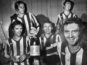 Wigan Athletic goalscoring hero Maurice Whittle holds the champagne as he celebrates with team-mates Mickey Worswick and Billy Styles, front, and John Wilkie and Kenny Morris after the match against Division 3 Sheffield Wednesday in the FA Cup 2nd round match at Springfield Park on Saturday 17th of December 1977. Latics won the game 1-0.