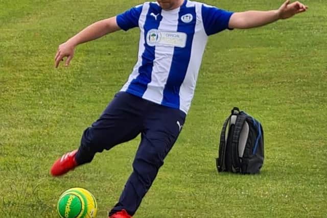 Oliver playing football in his Latics shirt.
