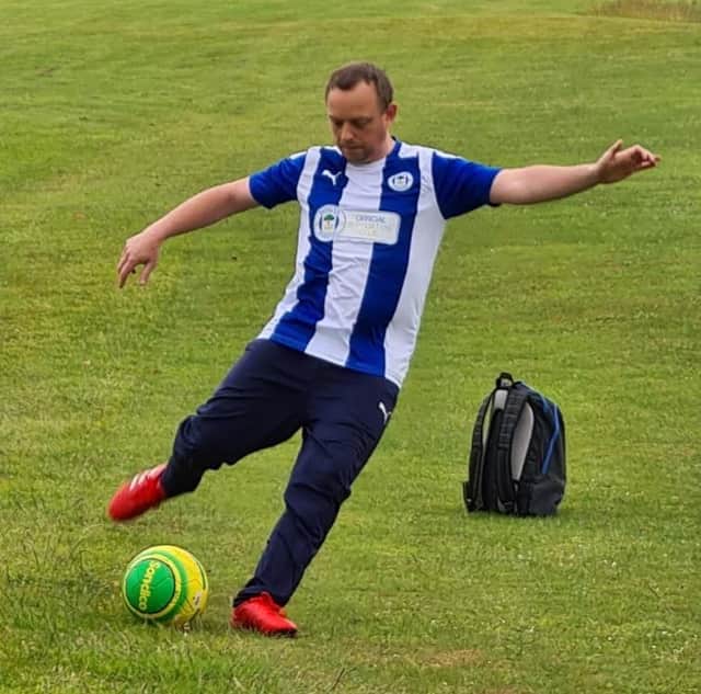 Oliver playing football in his Latics shirt.