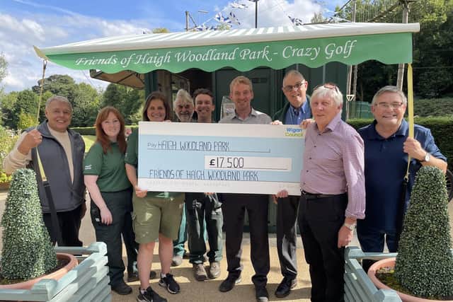 Chairman Ray Hinds (second from right) presents a cheque to staff at Haigh Woodland Park