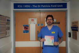 Wigan Infirmary ICU nurse Mark Ainscough with his children's book, Freddie and the Magic Heart