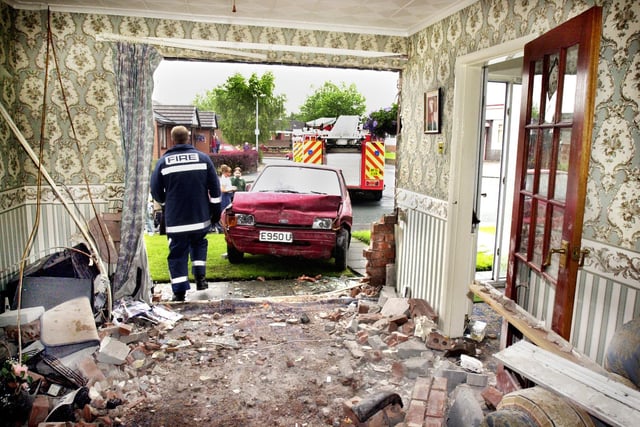 The devastation caused by a car crashing into Gordon Griffin's house in Morris Street, Scholes, on Friday 19th of July 2002. 
The Ford Fiesta smashed through the front of his house pinning him to the wall of his lounge and landed on top of him but he luckily escaped serious injury.
The driver also wasn't badly injured but was arrested.