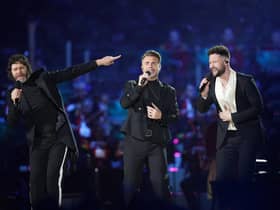 Howard Donald and Gary Barlow of Take That, perform with Callum Scott (right) on stage during the Coronation Concert