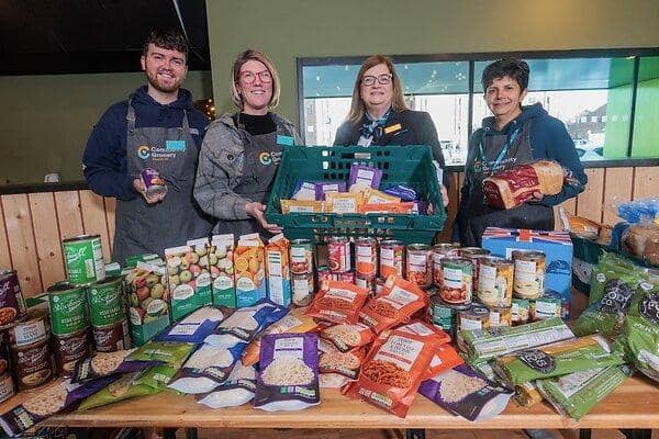 Miller Homes Development Sales Manger Jo Murray and Wigan Community Grocery Assistant Manager Oliver Ross, Manager Emily Olurankinse and Volunteer Elizabeth Serhan with some of the donated food.