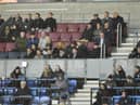 Wayne Rooney (centre of picture, wearing cap) was an interested spectator in the DW Stadium directors box on Monday night