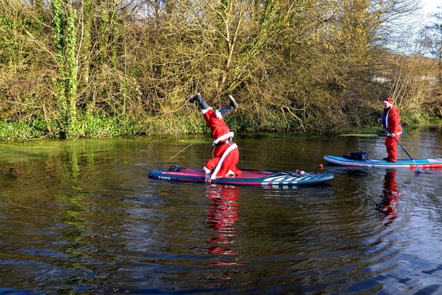Father Christmas doing a hand stand on his Paddle Board
