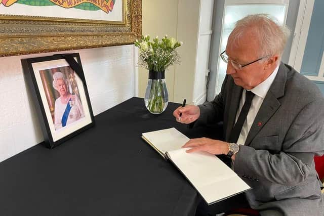 Coun David Molyneux signing the book of condolence at Wigan Town Hall