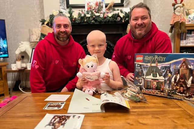 Holly's Hearts trustees Calvin Williams and Phil Barnes give a Harry Potter Lego set to six-year-old Harry, who is being treated for leukaemia
