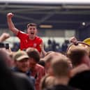 Kell Watts celebrates with the Latics fans after the League One title-winning victory at Shrewsbury last year