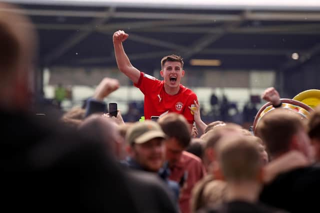 Kell Watts celebrates with the Latics fans after the League One title-winning victory at Shrewsbury last year