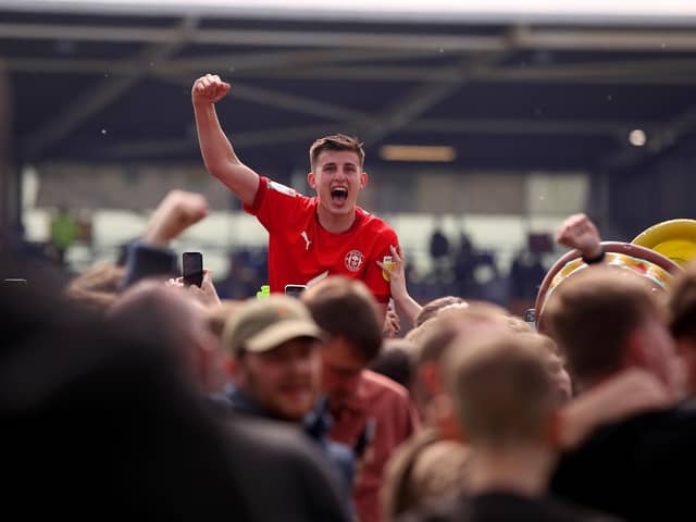 Kell Watts celebrates with the Latics fans after the League One title-winning victory at Shrewsbury last year