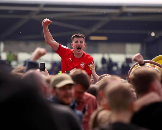Kell Watts celebrates with the Latics fans after the League One title-winning victory at Shrewsbury last year
