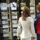 Couple standing outside an estate agent's window (file photo).