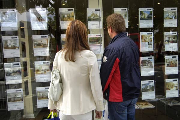Couple standing outside an estate agent's window (file photo).