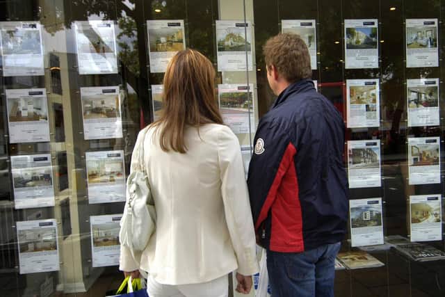 Couple standing outside an estate agent's window (file photo).