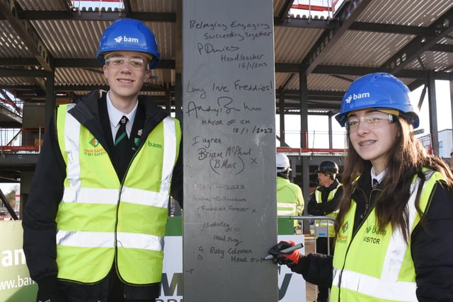 Head Boy Alfie Dunkerley and Head Girl Ruby Coleman sign their names on steel, part of the new school building.