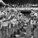 Long serving Wigan Athletic player Alex Cribley strides out at Springfield Park with children Michael and Tom through a guard of honour from junior players for his testimonial match against Everton on Sunday 6th of May 1990.