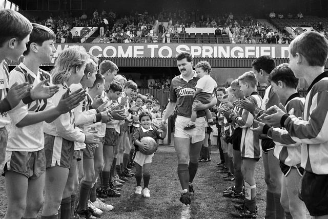 Long serving Wigan Athletic player Alex Cribley strides out at Springfield Park with children Michael and Tom through a guard of honour from junior players for his testimonial match against Everton on Sunday 6th of May 1990.