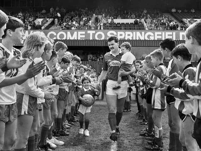 Long serving Wigan Athletic player Alex Cribley strides out at Springfield Park with children Michael and Tom through a guard of honour from junior players for his testimonial match against Everton on Sunday 6th of May 1990.