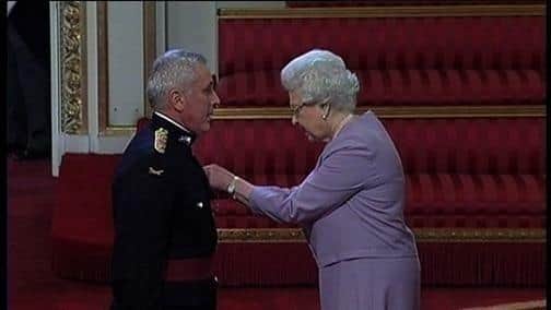 A proud John Harker receives his MBE from the Queen