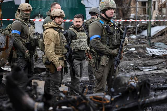 President Volodymyr Zelensky walks in the town of Bucha where bodies were found lying in the street after the town was retaken by the Ukrainian army