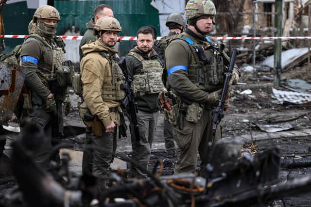 President Volodymyr Zelensky walks in the town of Bucha where bodies were found lying in the street after the town was retaken by the Ukrainian army