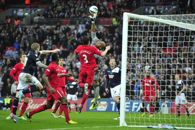 Wigan Athletic's Omani goalkeeper Ali Al Habsi (C) stretches to reach the ball clear