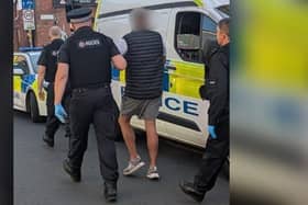 A suspect is led away after the Union Street police raid