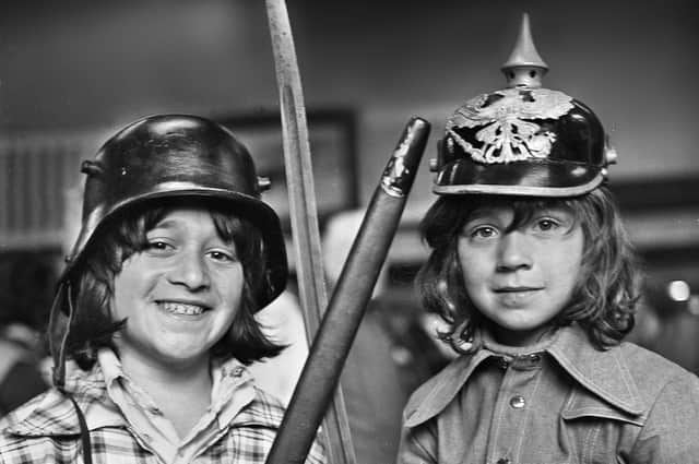 Maurice Cohen wearing a World War One German steel helmet and sister Michelle sporting a German Pickelhaube which they spotted at a flea market in the Queen's Hall, Wigan, on Saturday 24th of May 1975.