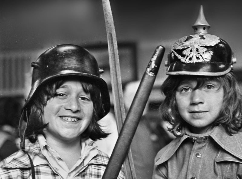 Maurice Cohen wearing a World War One German steel helmet and sister Michelle sporting a German Pickelhaube which they spotted at a flea market in the Queen's Hall, Wigan, on Saturday 24th of May 1975.